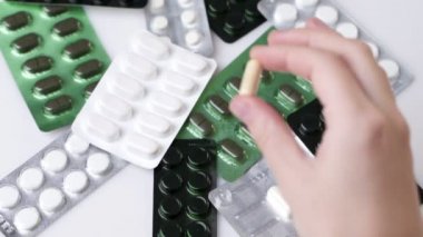 Tablet paketlerinin arka planında izole edilmiş bir kapsül ya da hap tutan