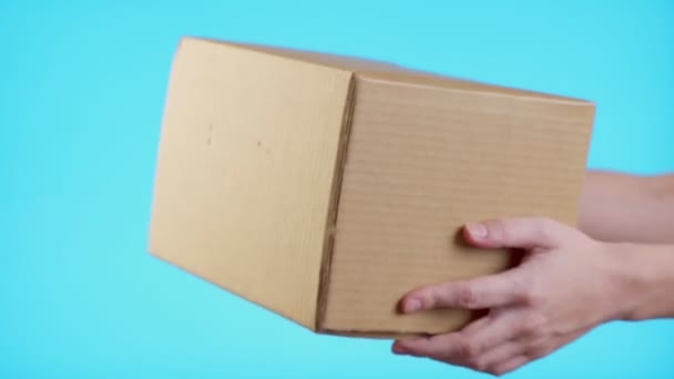 Zwei Hände nehmen eine Schachtel Geschenk auf blauem Hintergrund — Stockvideo