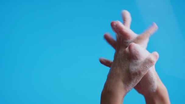 Hände waschen ihre Hände mit Seifenschaum auf blauem Hintergrund, Nahaufnahme. Prävention gegen Covid19, Bakterien, Gesundheitskonzept. — Stockvideo