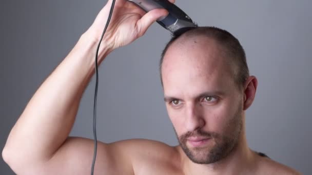Bir adam saç makasıyla kafasını tıraş eder. — Stok video
