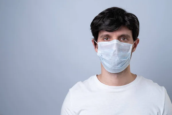 Homem em uma máscara médica, isolado em um fundo cinza — Fotografia de Stock