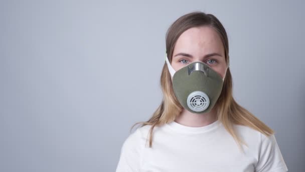 Woman in a respiratory mask, isolated on a gray background — Stock Video