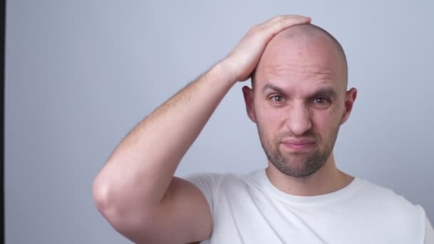 En skallig man sätter på sig en peruk — Stockvideo