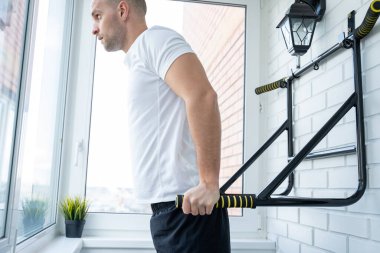 Fitness adamı evdeki barda egzersiz yapıyor.