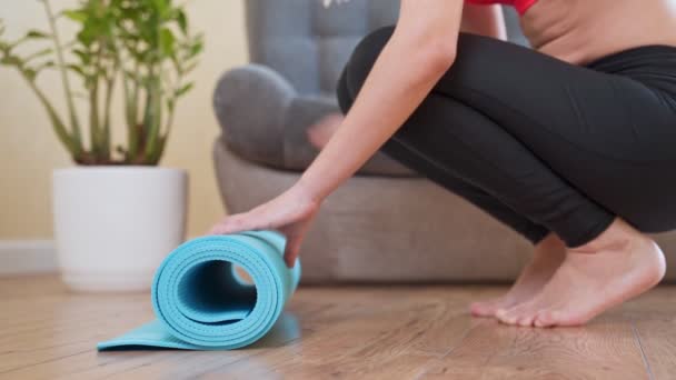 Tapis de fitness ou de yoga roulant femme avant la pratique du sport, s'entraînant à la maison dans le salon ou dans le studio de yoga. Habitudes saines, garder la forme, concepts de perte de poids . — Video