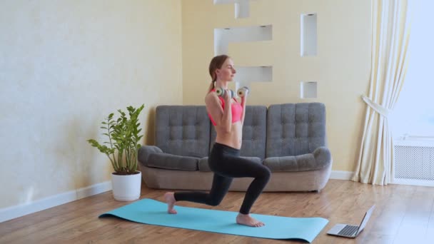 Atletische vrouw opwarming van de aarde omhoog doend gewogen lunges met halters training oefening voor kont benen op home gezonde levensstijl sport bodybuilding concept. — Stockvideo