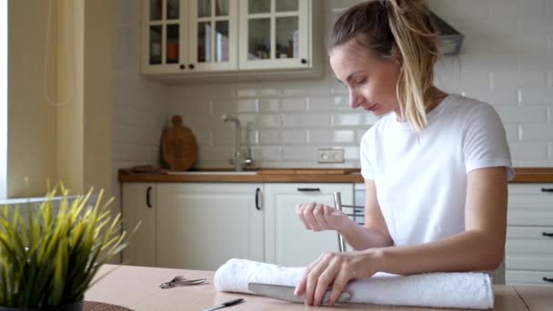 Aantrekkelijke jonge vrouw doet manicure thuis, glimlachend meisje archiveren vormgeven nagels met emery board — Stockvideo