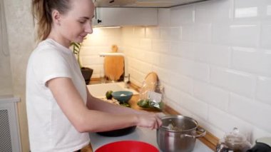 Bir kadın akşam yemeği hazırlar. Bıçakla mantar keser.