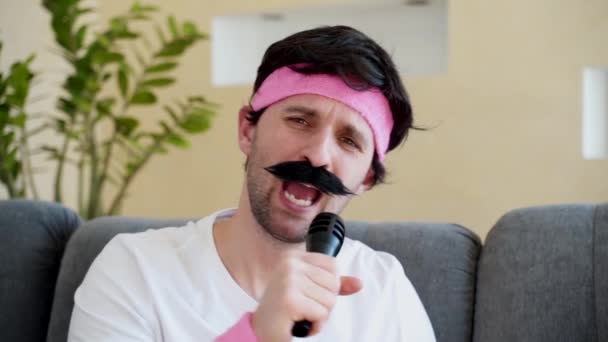 Zabawny człowiek z wąsami śpiewa do mikrofonu. — Wideo stockowe