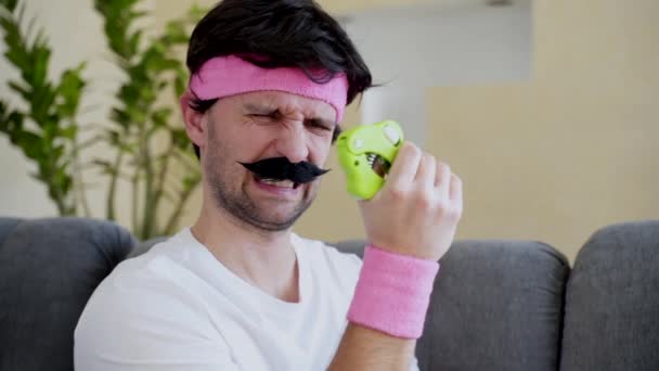 A funny man with a mustache clutches a hand trainer — Stock Video