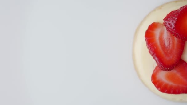 Tarta de queso con fresas gira sobre un aislado sobre fondo blanco . — Vídeo de stock