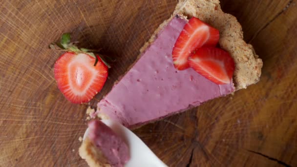 Cuillère prend un morceau de délicieux gâteau au fromage aux fraises. La vue du haut — Video