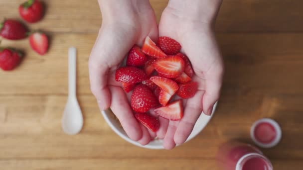 Полуниця падає в миску з йогуртом з граноли — стокове відео