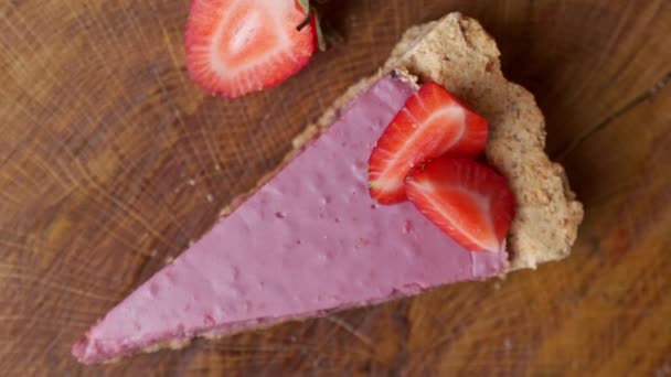 Vue de dessus des fraises fraîches avec une tranche de gâteau au fromage aux fraises tourner — Video