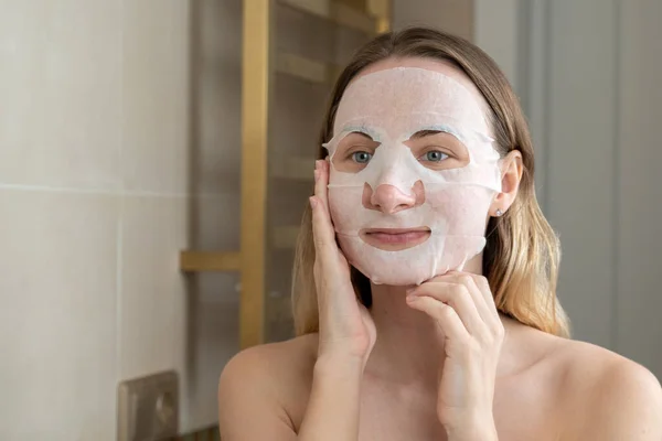 Giovane donna che fa maschera purificante sul suo viso — Foto Stock