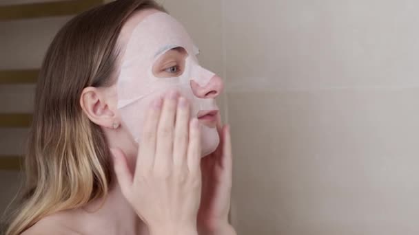 Jovem mulher fazendo máscara purificadora em seu rosto — Vídeo de Stock