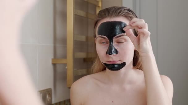 Hermosa mujer quitándose la mascarilla elástica negra de su cara — Vídeos de Stock