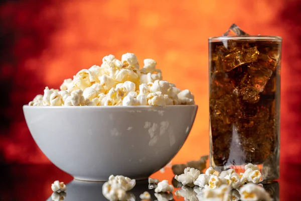 Skleněná mísa s čerstvým popcornem a kolou — Stock fotografie