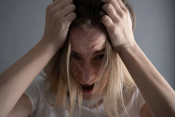 Vorderansicht einer verängstigten Frau, die mit den Händen auf dem Kopf schreit — Stockfoto