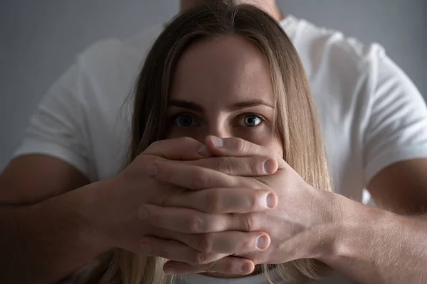 Víctima de violencia doméstica. Violencia contra las mujeres, Mujer asustada con mano de hombre cubriéndose la boca — Foto de Stock