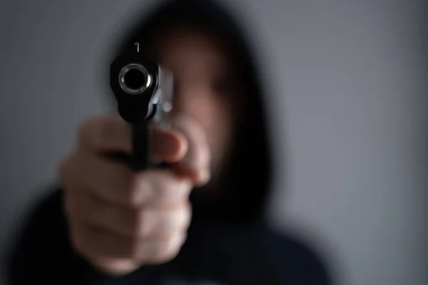 Criminal aiming gun camera, threatening burglar at victim