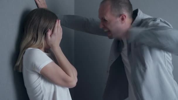 Angry husband trying to hit his wife indoors. Concept of domestic violence — Stock Video