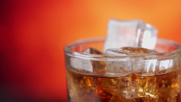 Cola con cubitos de hielo rotan de cerca. Cola con hielo y burbujas en vidrio. Primer plano de soda . — Vídeos de Stock