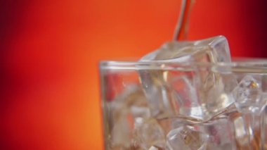 Yakından buz küpleriyle kola dolduruyorum. Buzlu kola ve camda kabarcıklar..