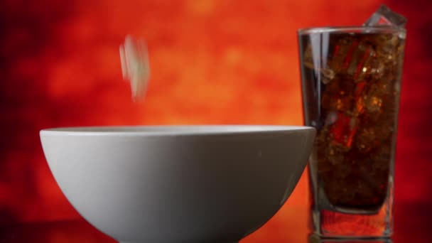 Palomitas de maíz caen en un plato sobre una mesa en cámara lenta — Vídeo de stock