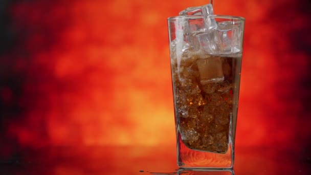 Verter Cola con cubitos de hielo de cerca. Cola con hielo y burbujas en vidrio. — Vídeos de Stock