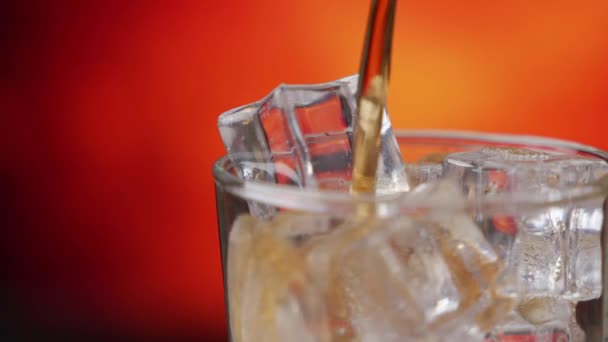 Cola in Großaufnahme mit Eiswürfeln übergießen. Cola mit Eis und Blasen im Glas. Coke Soda Nahaufnahme. — Stockvideo