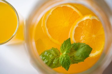 Bir sürahi sağlıklı limonata, portakal, nane ve buz kokteyli.