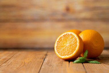 Tahta bir masada üç taze portakal.