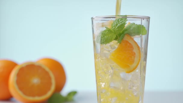 Yellow lemonade pouring in the glass from the pitcher. Making bubbles. Slow motion — Stock Video