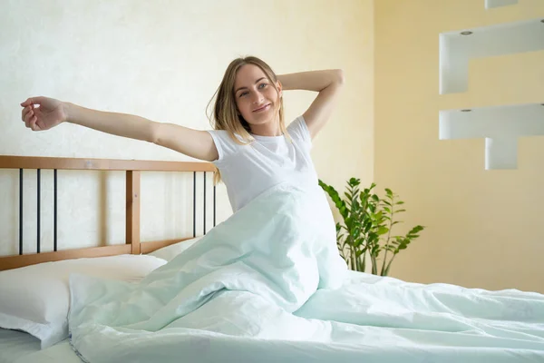 Woman waking up in her bed fully rested. Woman stretching in bed after wake up. — Stock Photo, Image