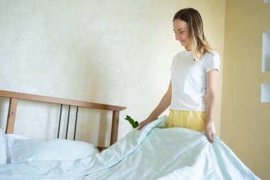 Kadın çok yumuşak ve temiz çarşaflara dokunuyor..