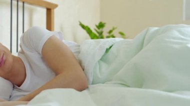 Kadın yatakta uyuyor ve sabahları dinleniyor.