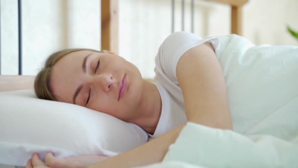Жінка спить у ліжку і розслабляється вранці — стокове відео