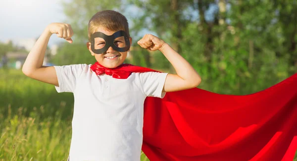 Superhelden-Kind zeigt seine Muskeln — Stockfoto