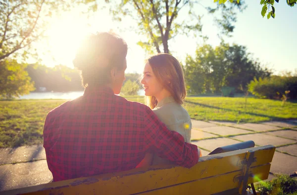 Jovem casal sentado no parque de outono . — Fotografia de Stock