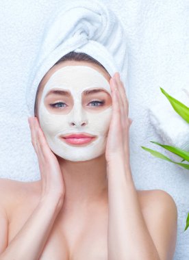 Yüz kil maskesi uygulayarak kafa havluya kızla Spa