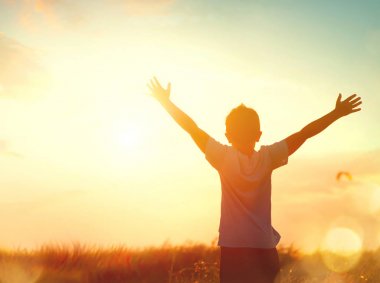 Küçük çocuk siluet yükselterek eller üzerinde gökyüzü günbatımı