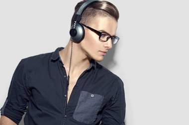 genç adam kulaklıklar gri arka plan üzerinde müzik keyfi