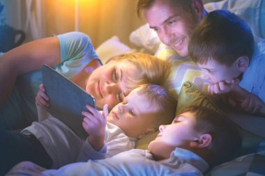 tablet bilgisayar karanlık odada film izlerken birlikte aile