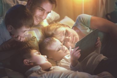 tablet bilgisayar karanlık odada film izlerken birlikte aile