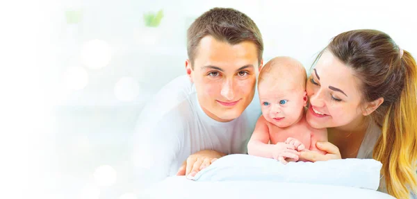 幸せな若い家族は白い背景で生まれたばかりの赤ちゃんと — ストック写真