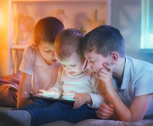 Tres Niños Pequeños Con Tablet Cuarto Oscuro —  Fotos de Stock