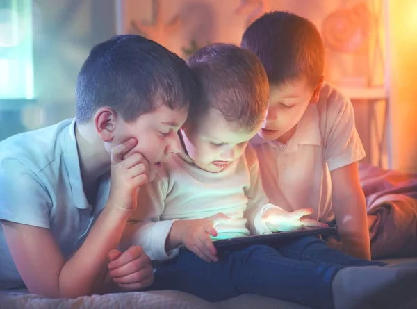 Три Маленьких Мальчика Планшетным Компьютером Темной Комнате — стоковое фото