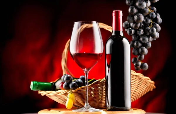 酒瓶和红酒与成熟的葡萄在黑色背景 — 图库照片