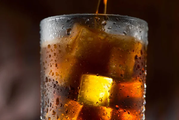 Cola Derramando Vidro Com Cubos Gelo Sobre Fundo Escuro — Fotografia de Stock